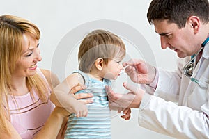 Doctor giving medicament to kid with a spoon