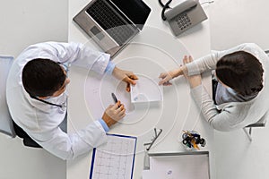 Doctor giving prescription to patient at hospital