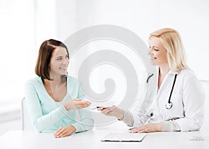 Doctor giving prescription to patient in hospital