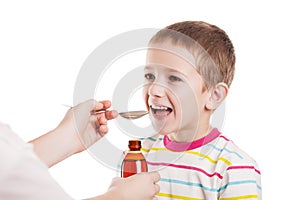 Doctor giving spoon of syrup to boy