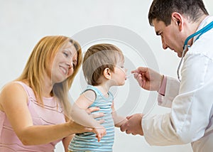 Doctor giving a spoon of syrup to little child