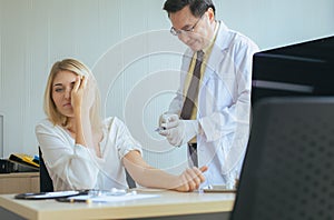 Doctor giving vaccine to frightened patient woman with injection or syringe in hospital