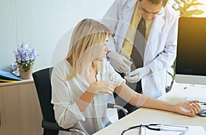 Doctor giving vaccine to female patient with injection or syringe in hospital room