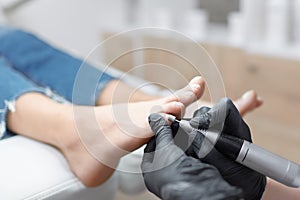 Doctor in gloves making procedure for foot with special equipment.