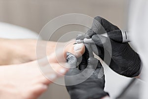 Doctor in gloves making procedure for foot with special equipment.