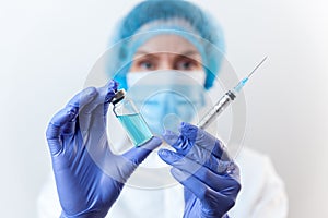 Doctor in gloves and mask holds bottle with vaccine, medicine