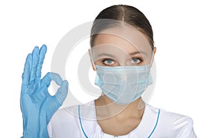 Doctor in gloves and mask shows gesture okay