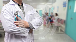 Doctor in gown uniform with stethoscope standing and fold his arms over the chest on OPD background