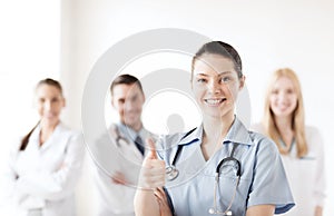 Doctor with group of medics showing thumbs up