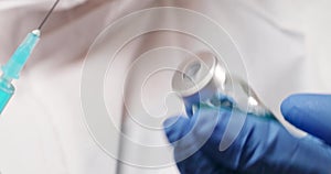 Doctor hand in blue medical gloves holding Coronavirus, Covid 19 virus, vaccine vial