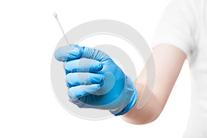 Doctor hand in a blue sterile glove holds to give cotton swab.