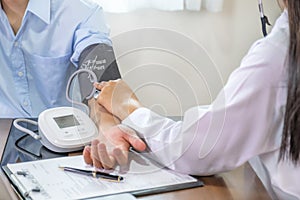 Doctor hand examines the patient's pulse with stethoscope and records the results, health medical checkup concept