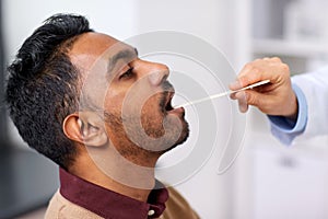 Doctor hand examining patient throat at clinic