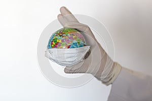 Doctor hand with glove holding world globe with face mask. Pandemic concept, Virus, Coronavirus, Covid-19, international emergency