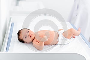 Doctor hand hold tiny Asian newborn baby sick sleeping during examine by pediatrician doctor with stethoscope, doctor monitoring