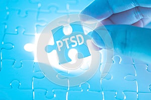 Doctor hand holding a jigsaw puzzle with PTSD - post traumatic s photo