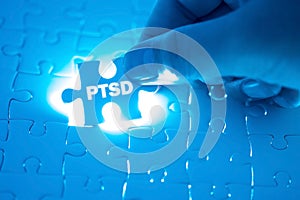 Doctor hand holding a jigsaw puzzle with PTSD - post traumatic s photo