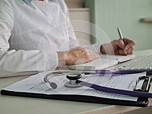 Doctor hand holding pen and notepad health insurance and education