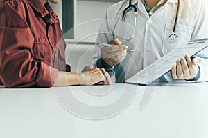 Doctor hand holding pen and talking to the patient about medication and treatment