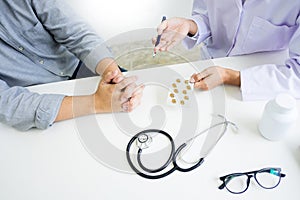 Doctor hand holding tablet of drug and explain to patient in hos