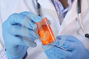 Doctor hand in protective glass holding pill container