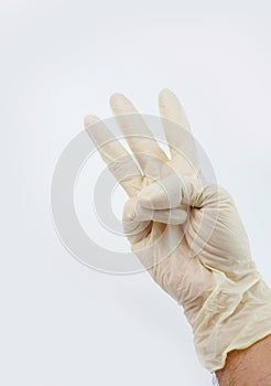 Doctor hand wearing gloves with three sign