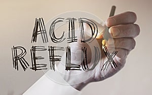 Doctor hand writing acid reflux words. Medical concept