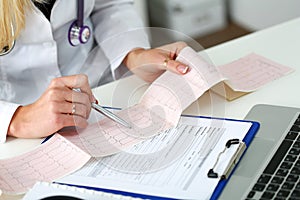 Doctor hands with cardiogram chart on clipboard pad