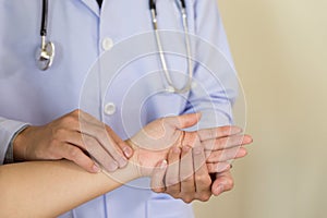 Doctor hands feeling pulse on female wrist