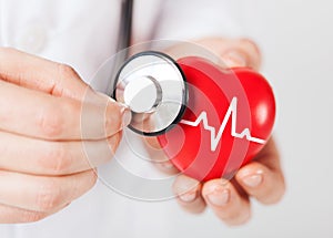 Doctor hands holding red heart and stethoscope