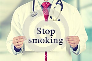 Doctor hands holding white card sign with stop smoking text message