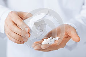 Doctor hands holding white pack and pills