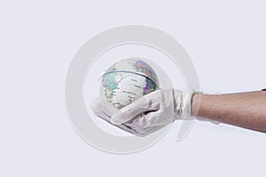 Doctor hands in medical surgical gloves hold miniature the earth globe