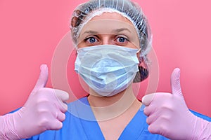 The doctor hands, in a pink medical glove, gives a thumbs - up gesture of approval. A nurse in a blue uniform makes a gesture that