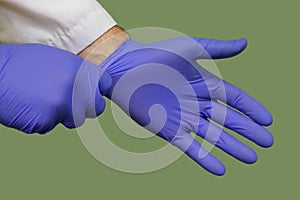 Doctor Hands Putting on Blue Nitrile Rubber Gloves Up Close