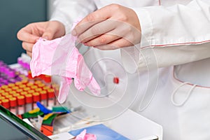 Doctor hands putting on pink latex gloves