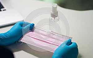 Doctor hands showing surgical mask on wood table. The concept of inviting people to donate medical masks during virus diseases