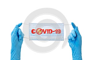 Doctor hands wear blue gloves holding face mask with covid-19 text and stop sign on light blue background for stop coronavirus