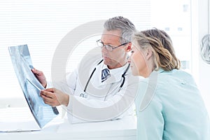 Doctor having conversation with his patient and holding xray