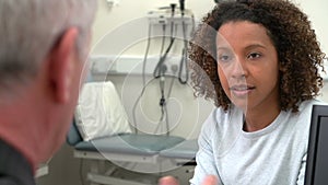 Doctor Having Discussion With Female Patient In Surgery