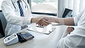 Doctor having shaking hands to congrats with patient after recommend sickness treatment while discussing explaining his symptoms