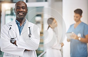 Doctor, healthcare and medicine with a man surgeon standing arms crossed in the hospital with his team in the background