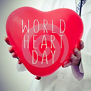 Doctor with a heart-shaped balloon with the text world heart day photo