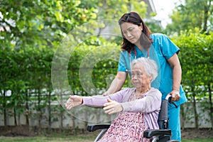Doctor help Asian senior or elderly old lady woman patient exercise on wheelchair with happy in park