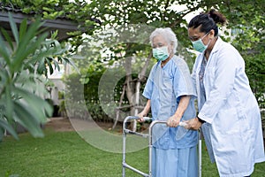 Doctor help and care Asian senior or elderly old lady woman use walker with strong health while walking at park in happy fresh