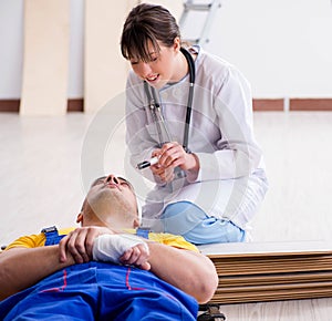 Doctor helping injured worker at construction site