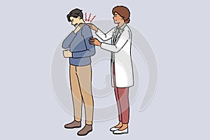 Doctor helping male patient with backache
