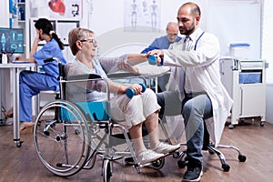Doctor helping old disabled woman