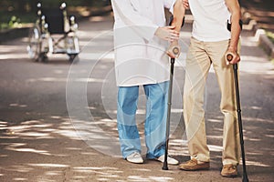 Doctor Helping Old Man Patient with Crutches.