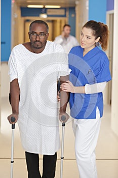 doctor helping patient with crutches